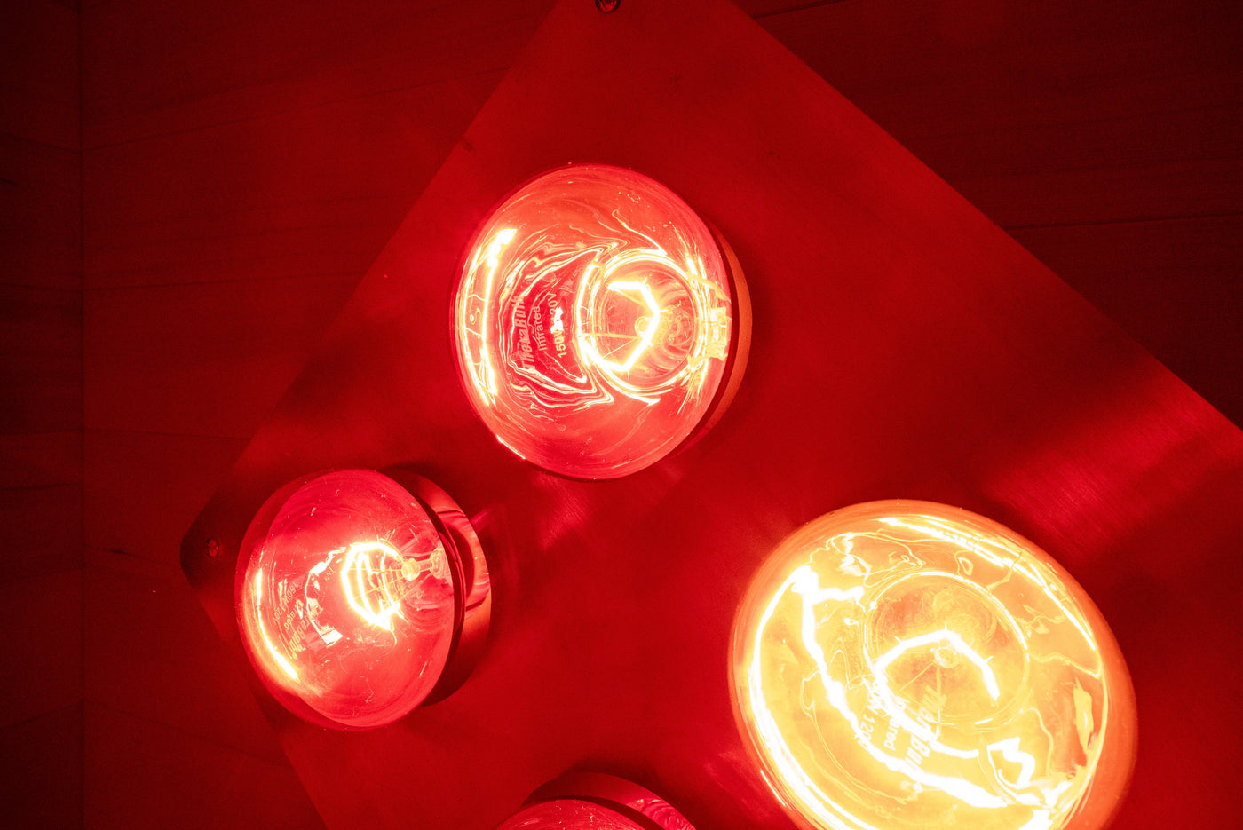 Close-up of SweatBox incandescent red light therapy bulbs glowing
