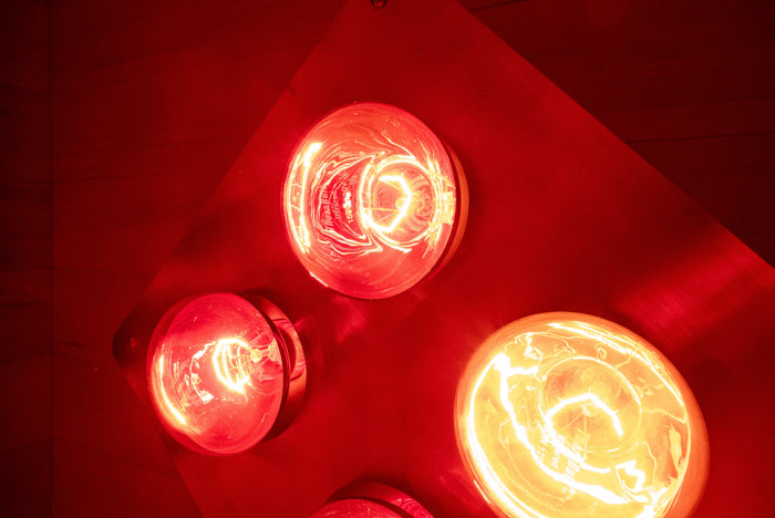 Close-up of SweatBox incandescent red light therapy bulbs glowing